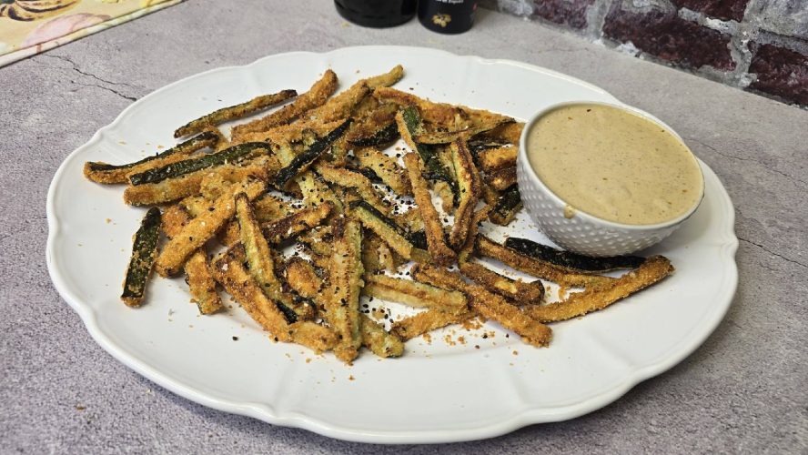 Bastones de calabacín crujientes al horno con parmesano, servidos sobre una salsa tonnata cremosa de atún y anchoas.