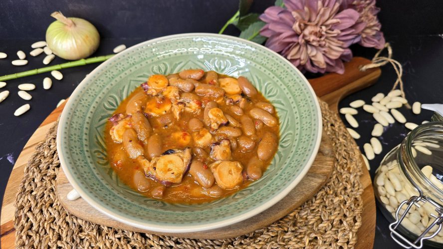 Fabes con pulpo cocido en un guiso marinero con pimientos, pimentón y caldo de pescado.